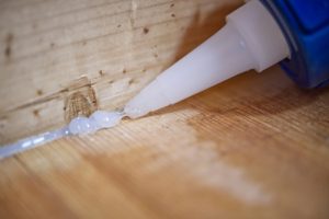 Use wood glue properly to repair floor gaps.
